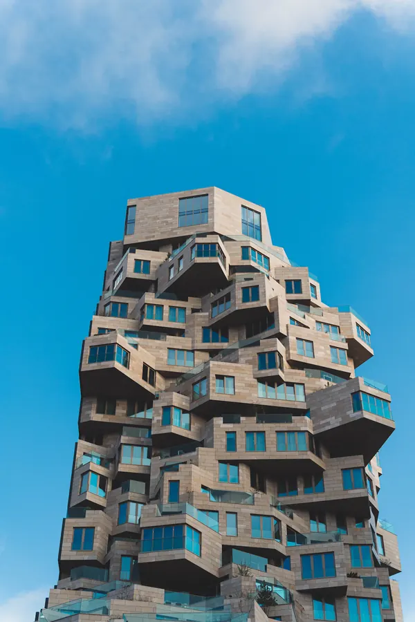 Een woongebouw met balkons en veel ramen.